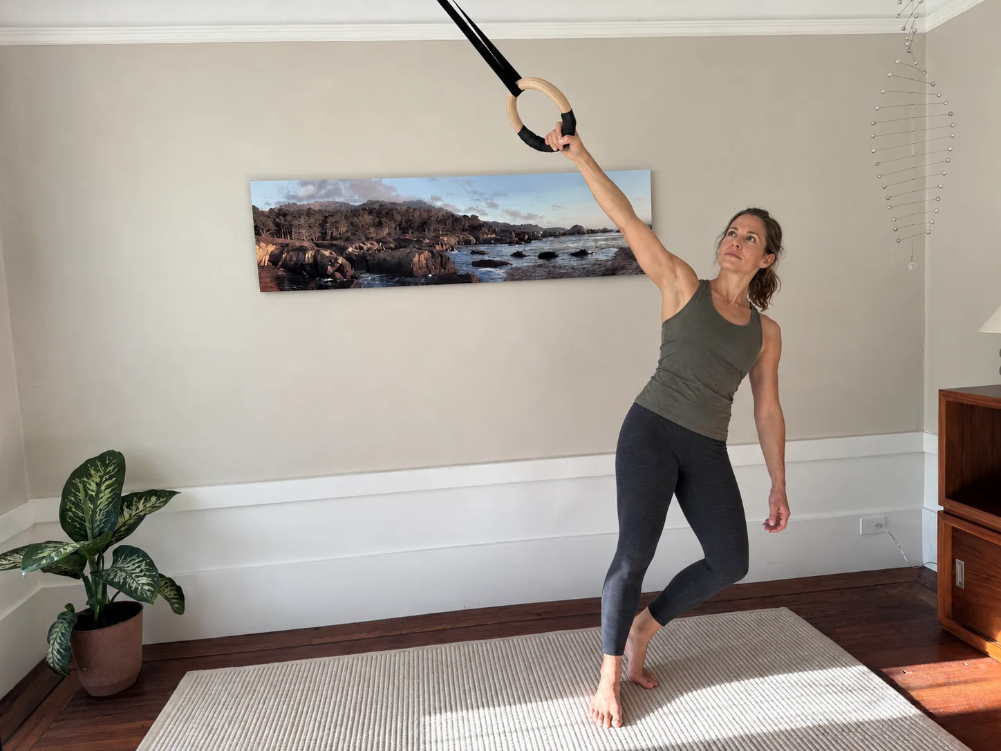 Woman leaning sideways while holding a suspension ring